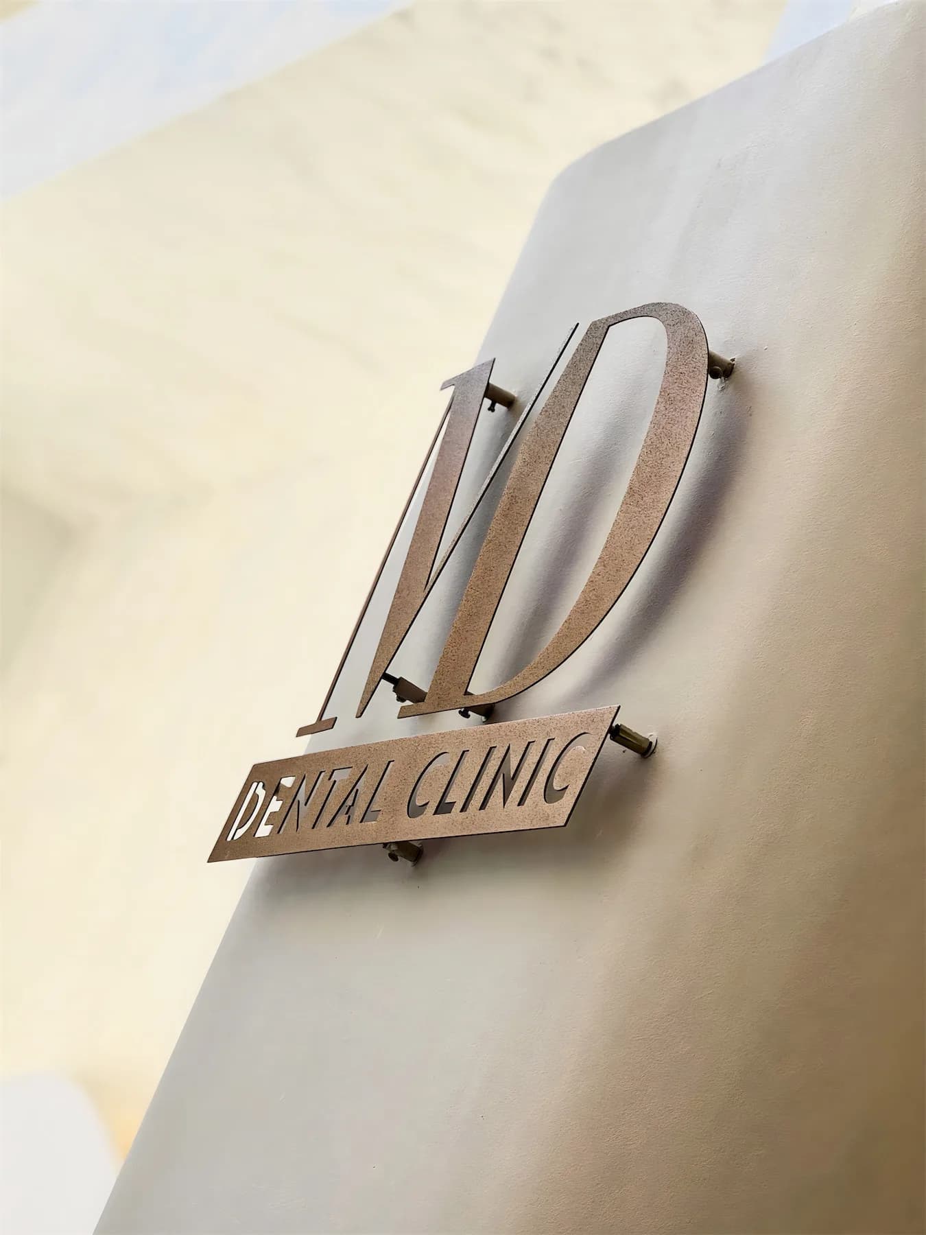 Bina cephesindeki bakır renkli MD Dental Clinic tabelası