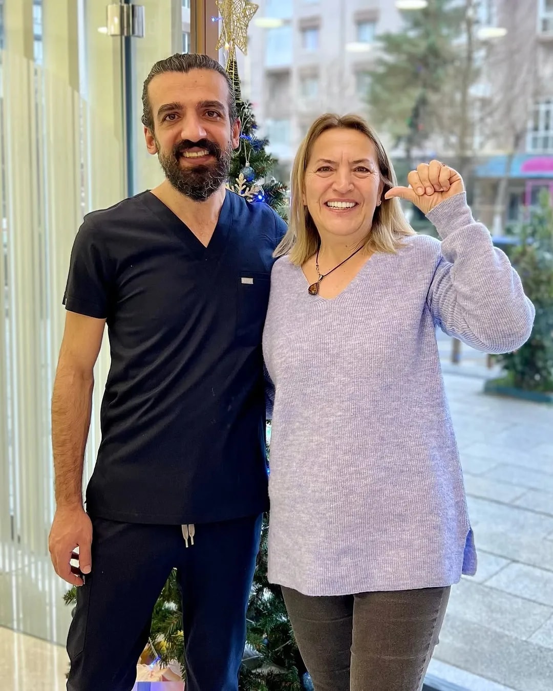 Dt. Ramazan İnkaya ve tedavisi tamamlanan hastası Mimar Diş kliniğinin girişinde